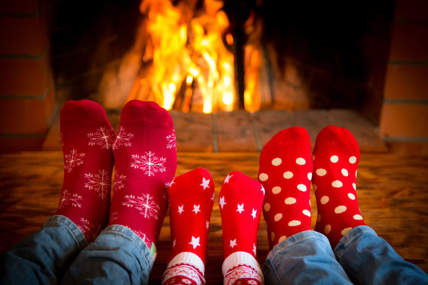 a family has their feet near the fire, keeping them warm and heathy with baby foot products