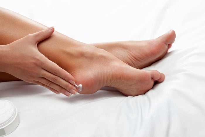 Applying foot cream to heels