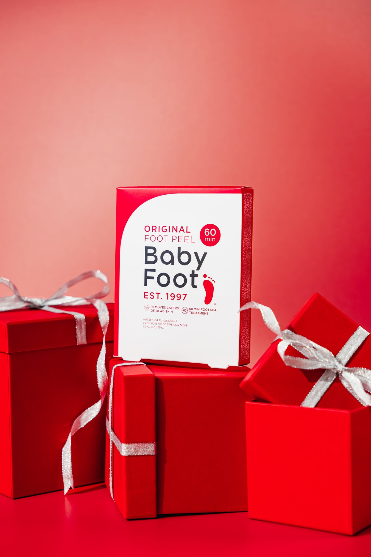 Two Baby Foot exfoliating foot peel packs with images of smooth, exfoliated feet on the packaging for kids and adults.