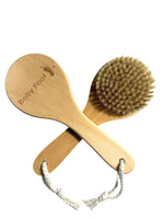 Baby Foot foot brush for exfoliating and cleaning feet, featuring soft bristles and ergonomic handle for effective foot care.